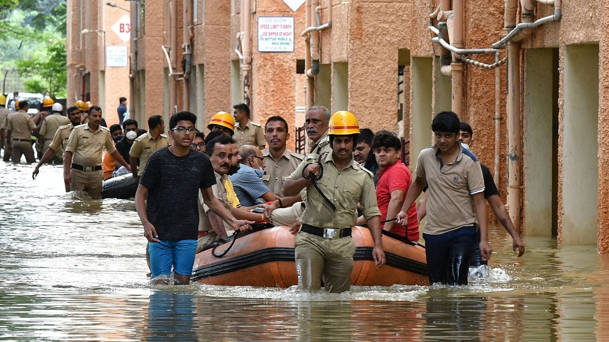 Members of Fire and Rescue Services evacuate people to safer places after heavy rains caused flooding in a residential area in Bengaluru. Credit: Reuters Photo