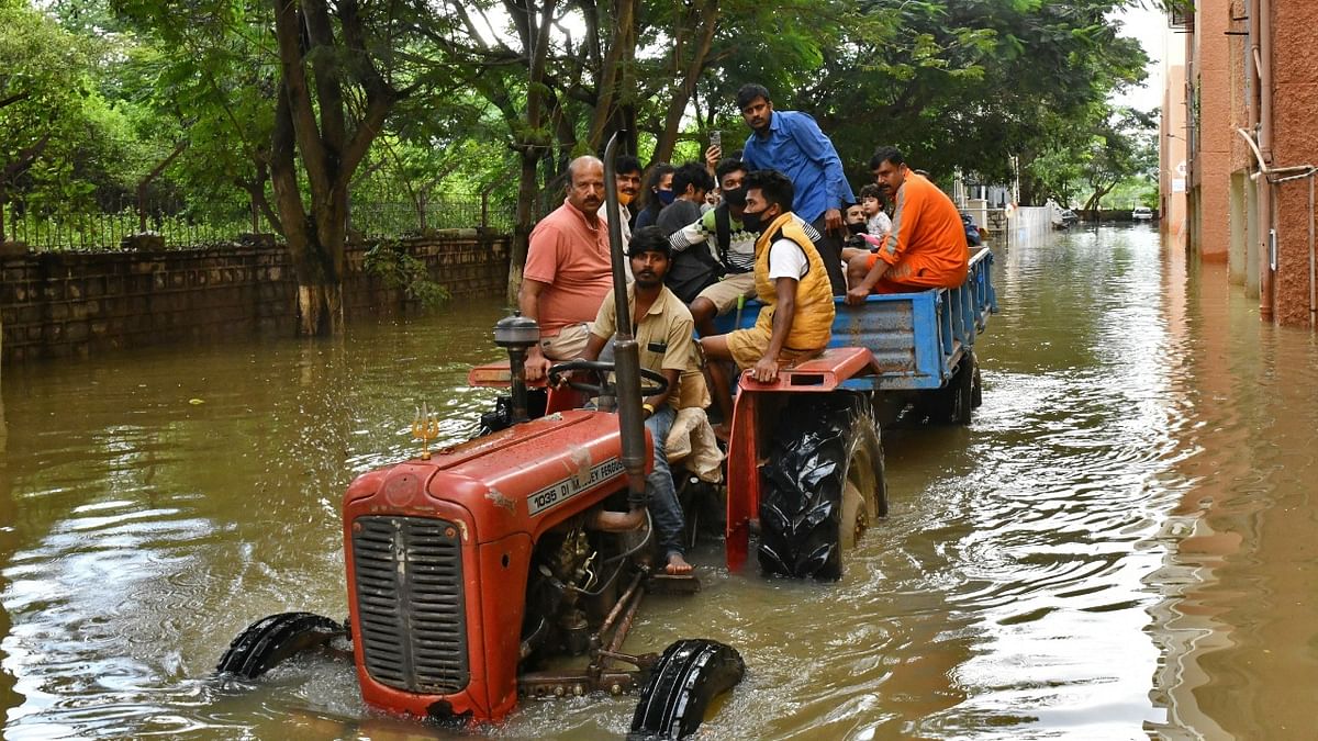 Residents were evacuated to safer places in a tractor trolley after heavy rains caused flooding in a residential area in Bengaluru. Credit: Reuters Photo