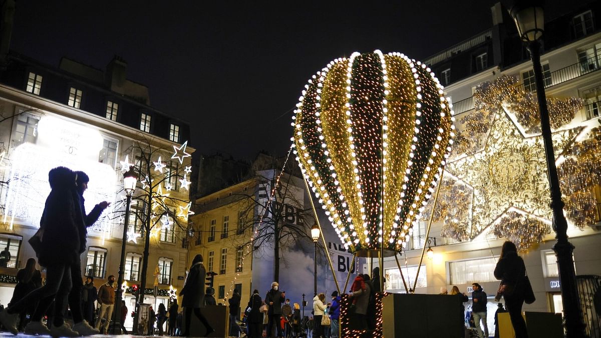People walk next to Dior store decorated with Christmas illuminations in Paris France. Credit: Reuters Photo