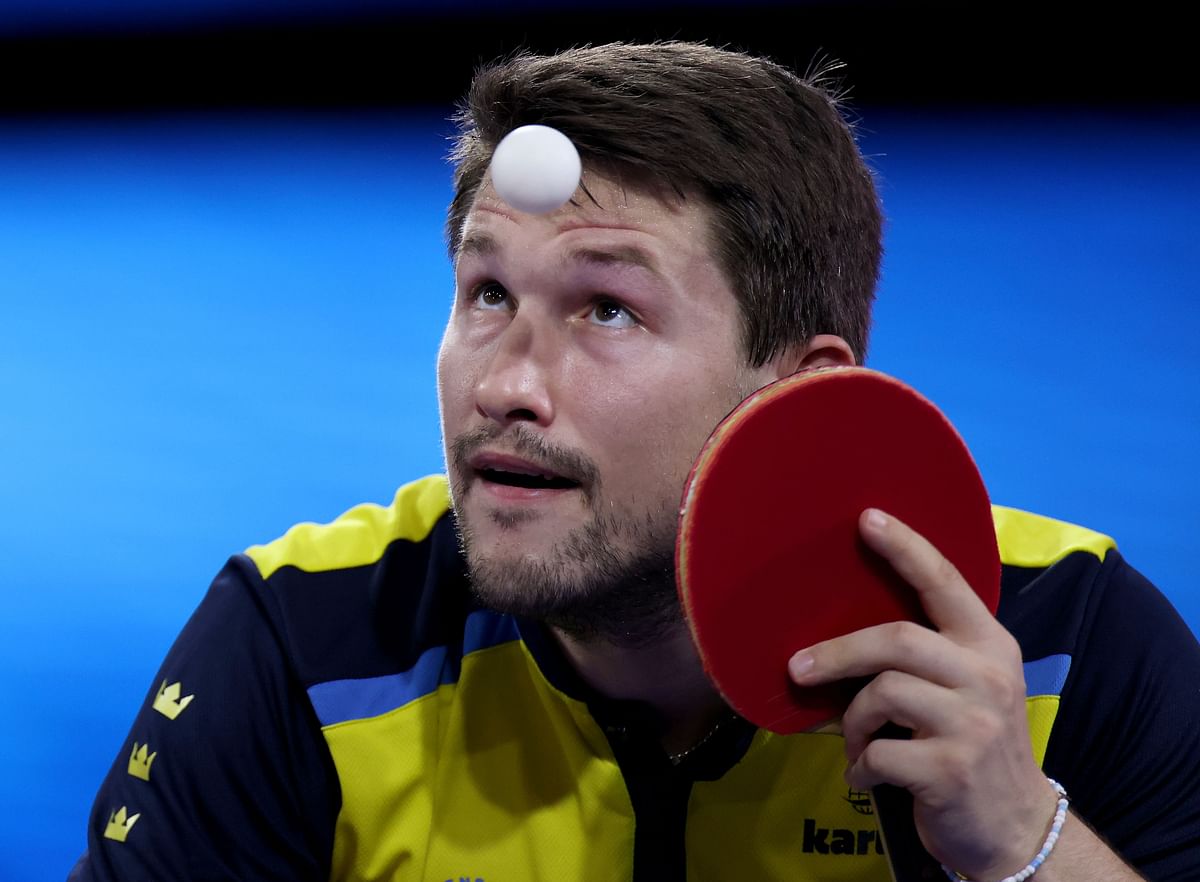 Kristian Karlsson of Sweden serves against Lin Gaoyuan and Liang Jingkun of China during the men's doubles semifinals match of the 2021 ITTF World Table Tennis Championships. Credit: AFP Photo