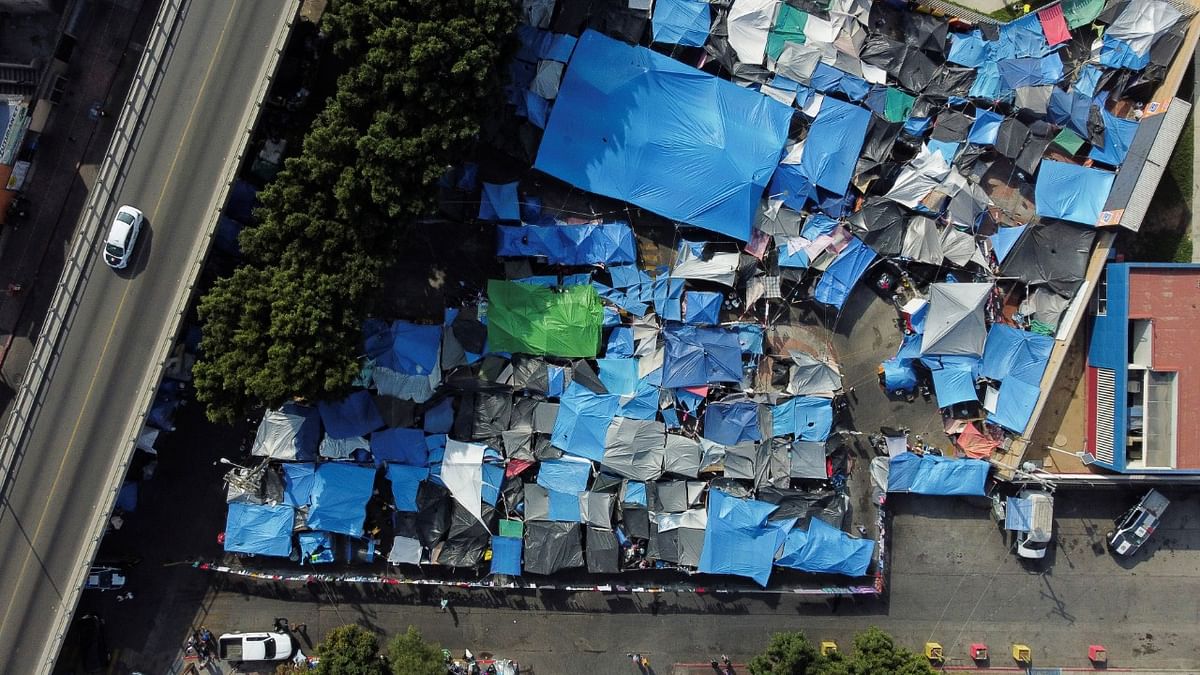 A general view shows a migrant makeshift camp as the Biden administration will restart a controversial Trump-era border program that forces asylum seekers to wait in Mexico for US immigration hearings, at El Chaparral crossing port with the US, in Tijuana, Mexico. Credit: Reuters Photo