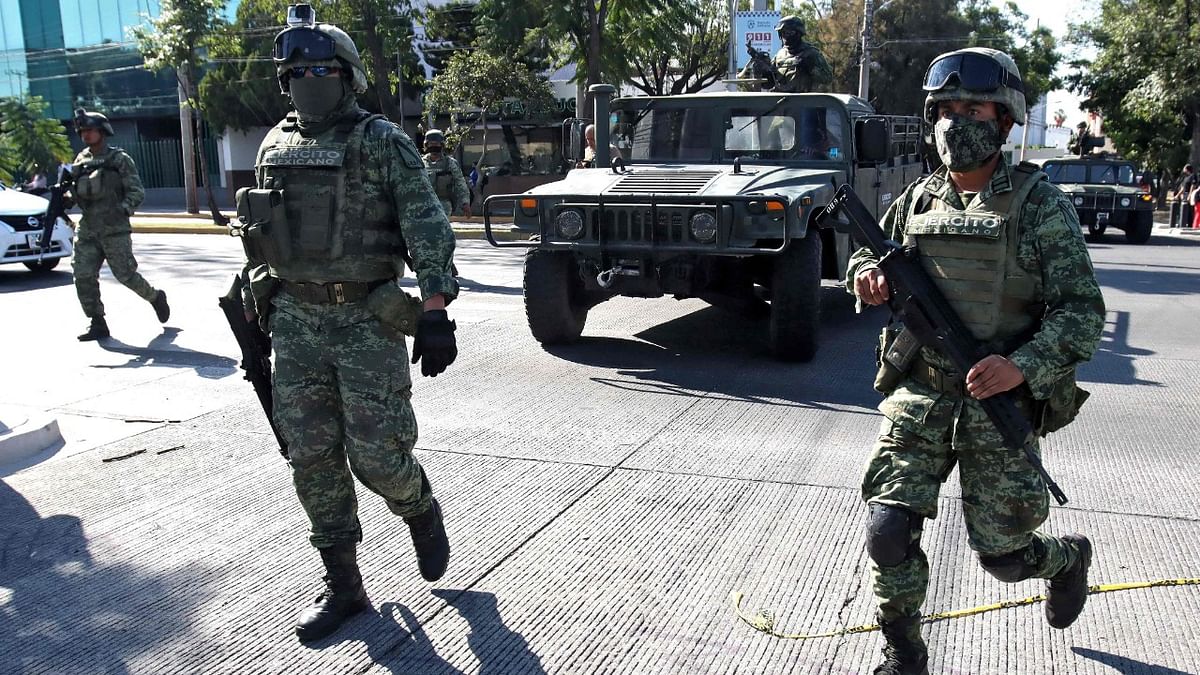 Members of the Army guard the street as they take part in an operation by the Armed Forces in Jardines de Alcalde neighbourhood in Guadalajara, Mexico, in which people were arrested and transferred. Credit: AFP Photo