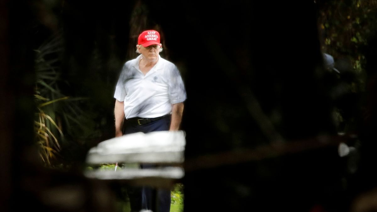 “As Trump traveled to Mar-a-Lago for Christmas holiday, Biden had won enough electoral votes to win the US presidency, but Trump hadn't conceded. Nobody had access to him, not even the press pool traveling with him. The news was dominated by the election, but there weren't any recent photos of Trump. Photog Brenner knew through a colleague about a spot in the fence of the Trump International Golf Club, from where it was possible to see Trump playing golf.” Credit: Reuters Photo