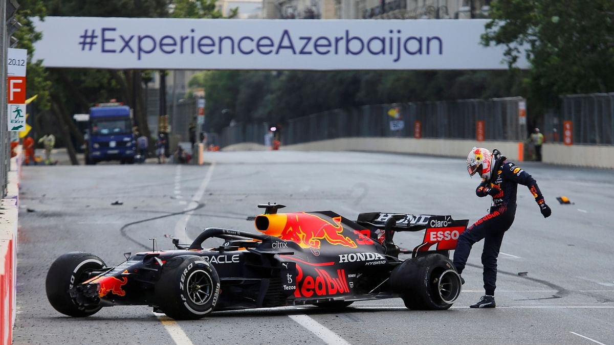 Dejected Max Verstappen of Red Bull is seen kicking the wheel of his car after crashing out of the race. Credit: Reuters Photo