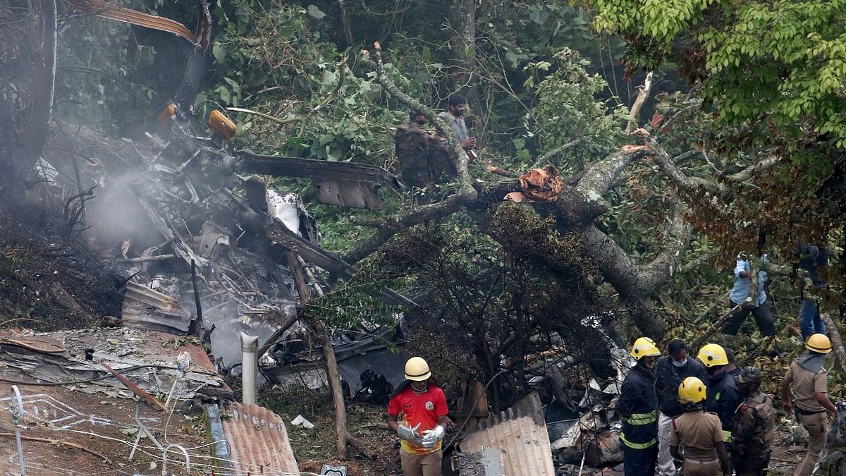Rescuers stand near the debris of the Russian-made Mi-17V5 helicopter after it crashed near the town of Coonoor in Tamil Nadu. Credit: Reuters Photo
