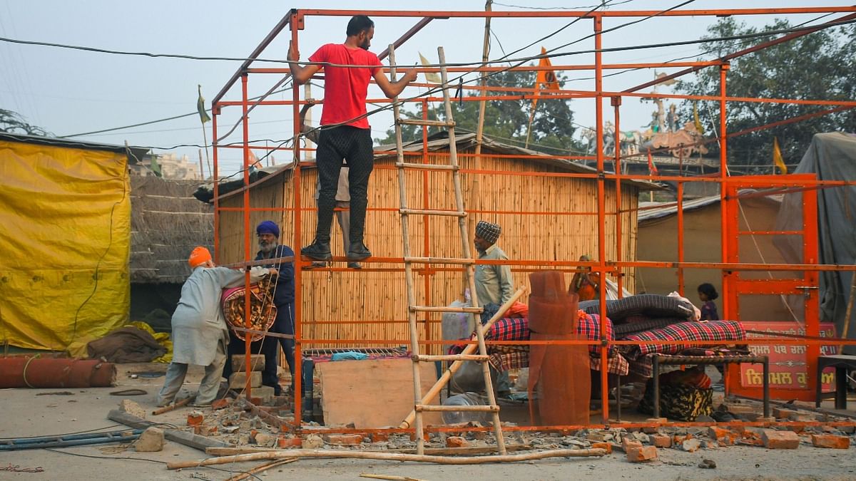 Farmers dismantle structures after a decision to withdraw farmers-movement in the wake of the government accepting all demands put forward by the agitating farmers, at Singhu border in New Delhi. Credit: PTI Photo