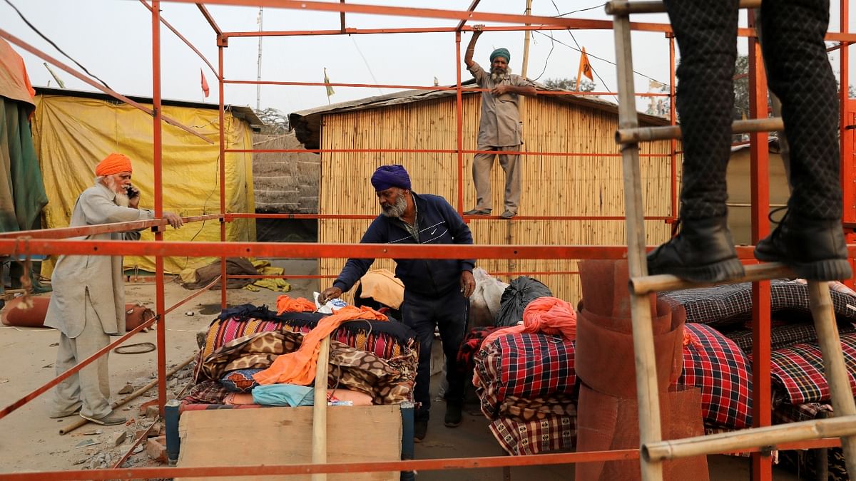 A farmer is seen packing his belongings after the protests were called off at the Singhu border protest site near the Delhi-Haryana border. Credit: Reuters Photo