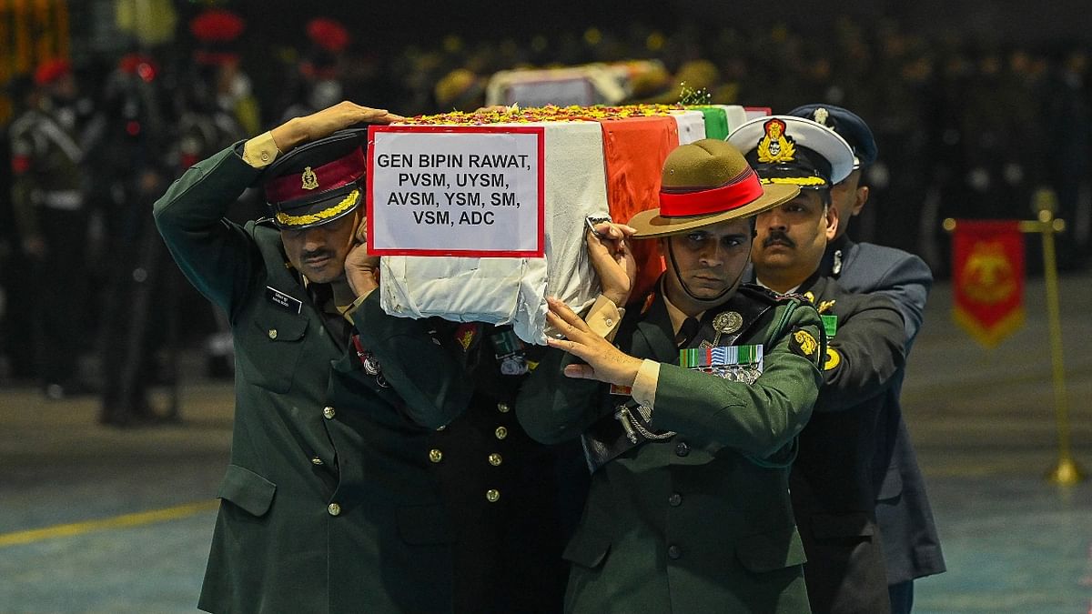 Army officers carry the coffins containing the mortal remains of India's defense chief General Bipin Rawat and other 12 victims who lost their lives in a helicopter crash a day earlier, during a tribute ceremony at Palam Air Force station in New Delhi. Credit: AFP Photo