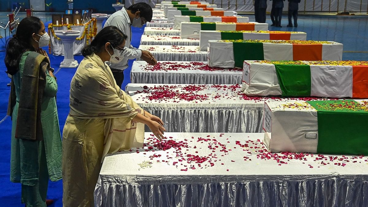 Daughters of India's Chief of Defence Staff Gen Bipin Rawat pay their respects during a tribute ceremony at Palam Air Force station in New Delhi. Credit: AFP Photo