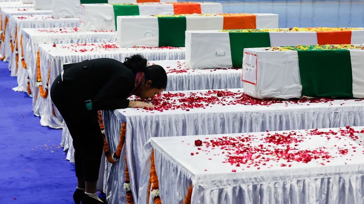 Daughter of Brigadier LS Lidder bids final goodbye to her father during a wreath laying ceremony at an airport in New Delhi. Credit: Reuters Photo