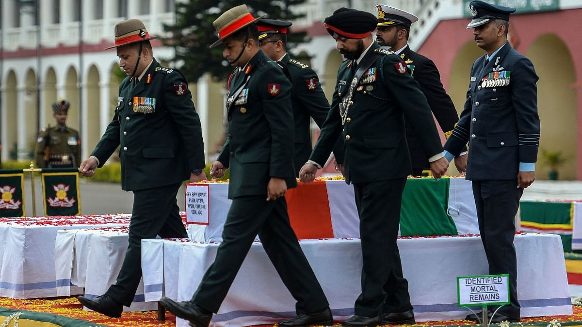 Army officers pay respect near the coffin containing the mortal remains of Indian defence chief General Bipin Rawat during a military funeral ceremony at the Madras regimental Center in Wellington, Tamil Nadu. Credit: AFP Photo