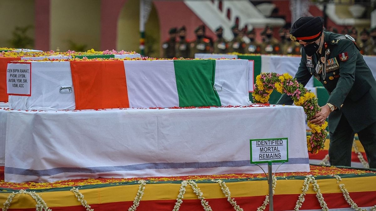 An Army officer pay respect to Indian defence chief General Bipin Rawat during a military funeral ceremony at the Madras regimental Center in Wellington, Tamil Nadu. Credit: AFP Photo