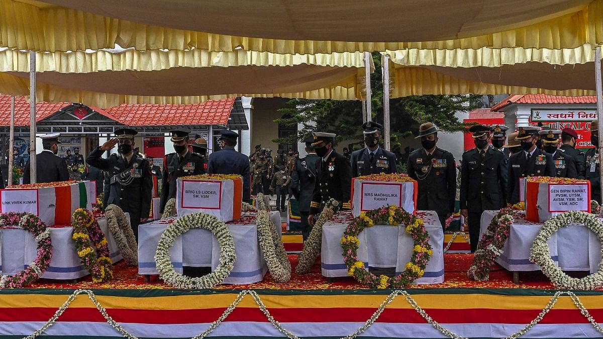 Army officers pay their last respects to the mortal remains of Indian defence chief General Bipin Rawat and 12 others who lost their lives in a helicopter crash in Coonoor during a military funeral ceremony at the Madras regimental Center in Wellington, Tamil Nadu. Credit: AFP Photo