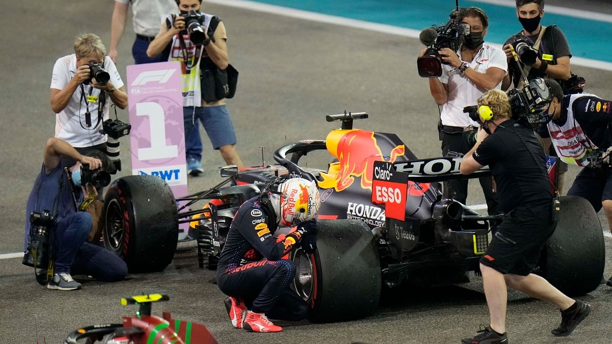 Red Bull driver Max Verstappen of the Netherlands kneels next to his car after he became the world champion after winning the Formula One Abu Dhabi Grand Prix in Abu Dhabi. Credit: AP Photo