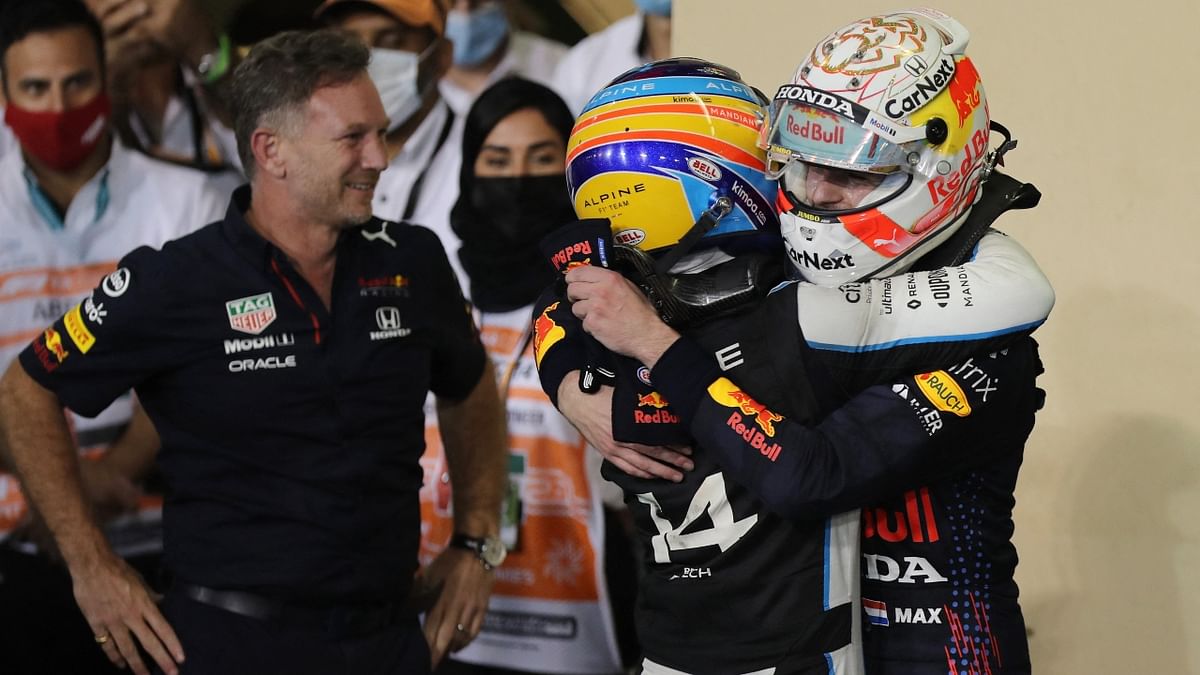 Red Bull's Max Verstappen celebrates winning the race and the world championship with Red Bull's Sergio Perez as team principal Christian Horner looks on. Credit: Reuters Photo