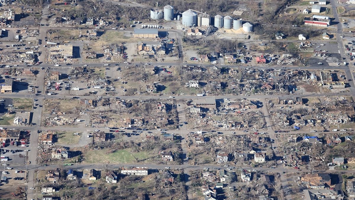 Mayfield, a town of about 10,000 near the westernmost tip of Kentucky, was perhaps the hardest-hit community: city blocks were leveled, historic homes and buildings were beaten down to their slabs, tree trunks had been stripped of their branches and cars lay overturned in fields. Credit: AFP Photo