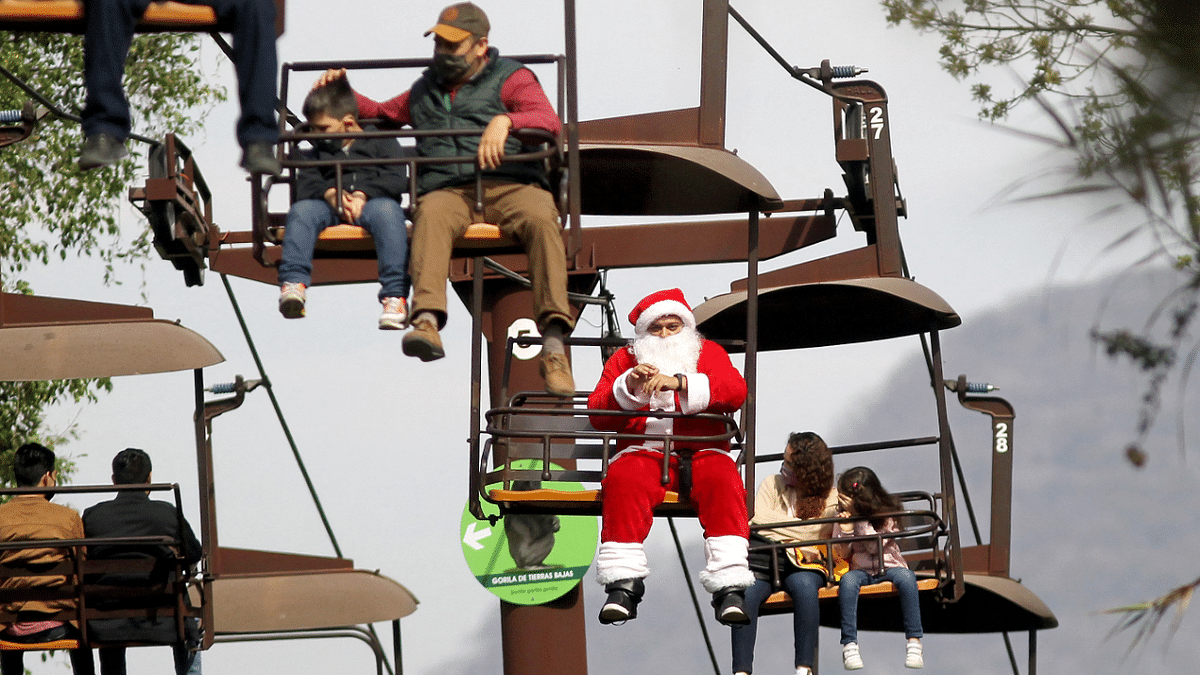 A man disguised as Santa Claus greets visitors to the Guadalajara Zoo from the cable car that runs through the facility just days before the Christmas holidays in Guadalajara, Mexico. Credit: AFP Photo