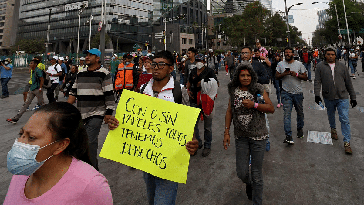 Migrants from Central America, Haiti, and Ecuador heading in a caravan towards the US, take part in a march commemorating the International Migrants Day, at the Reforma Avenue, in Mexico City. Credit: AFP Photo