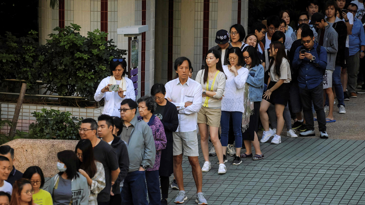 People queueing to cast their vote during the district council elections in South Horizons in Hong Kong. - Hong Kongers snubbed a legislature poll on December 19, 2021 taking place under new