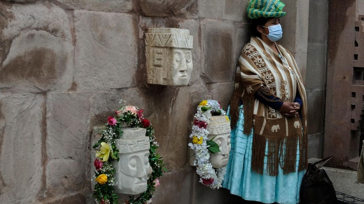An indigenous woman watches as an Amauta -Aymara indigenous priest- performs a Jallupacha (rainy season) ritual to thank the Pachamama (Mother Earth) on the summer solstice, in La Paz. Credit: AFP Photo