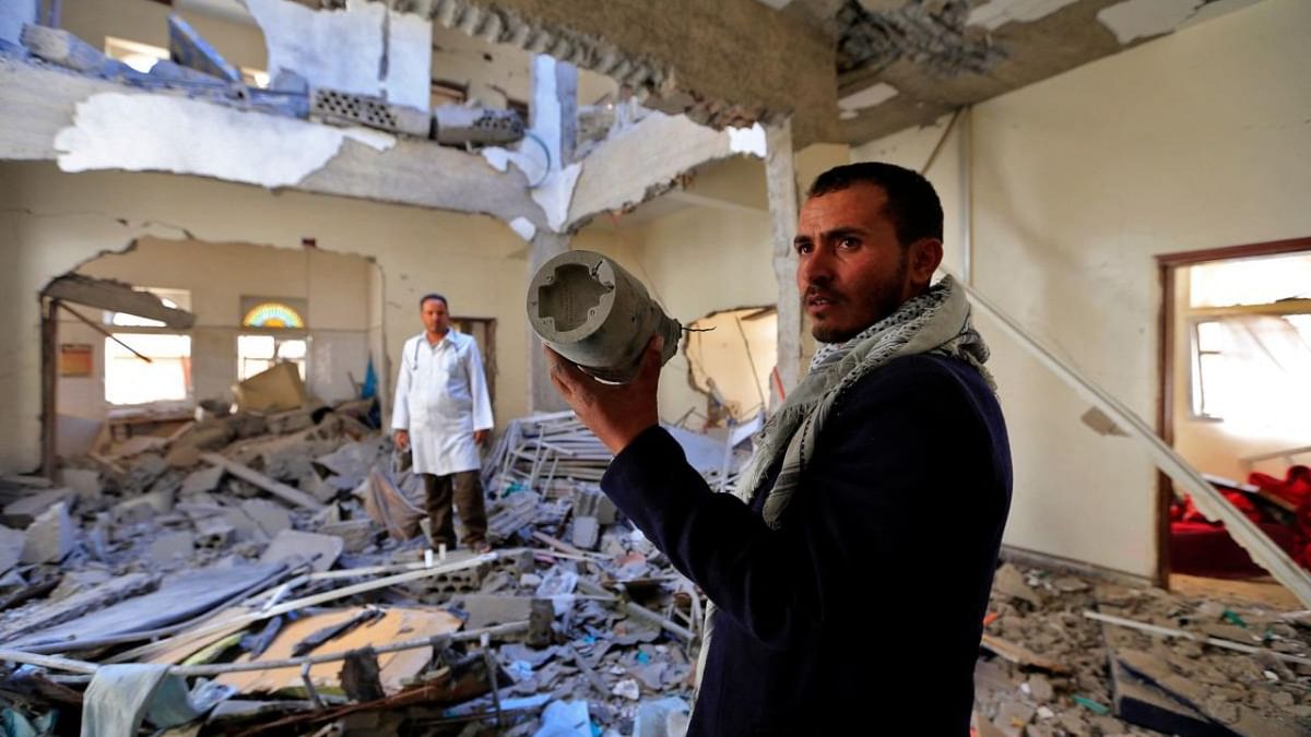 An airport worker holds what is reportedly the remains of a missile while inspecting the rubble inside a damaged building of the Huthi rebel-held Yemeni capital's Sanaa International Airport. Credit: AFP Photo