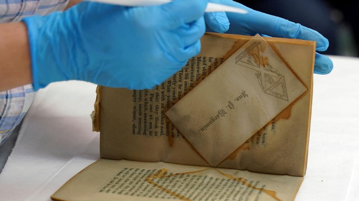 A person handles a book which was found in a time capsule recovered from Confederate General Robert E. Lee's monument, in Richmond, Virginia. Credit: Reuters photo
