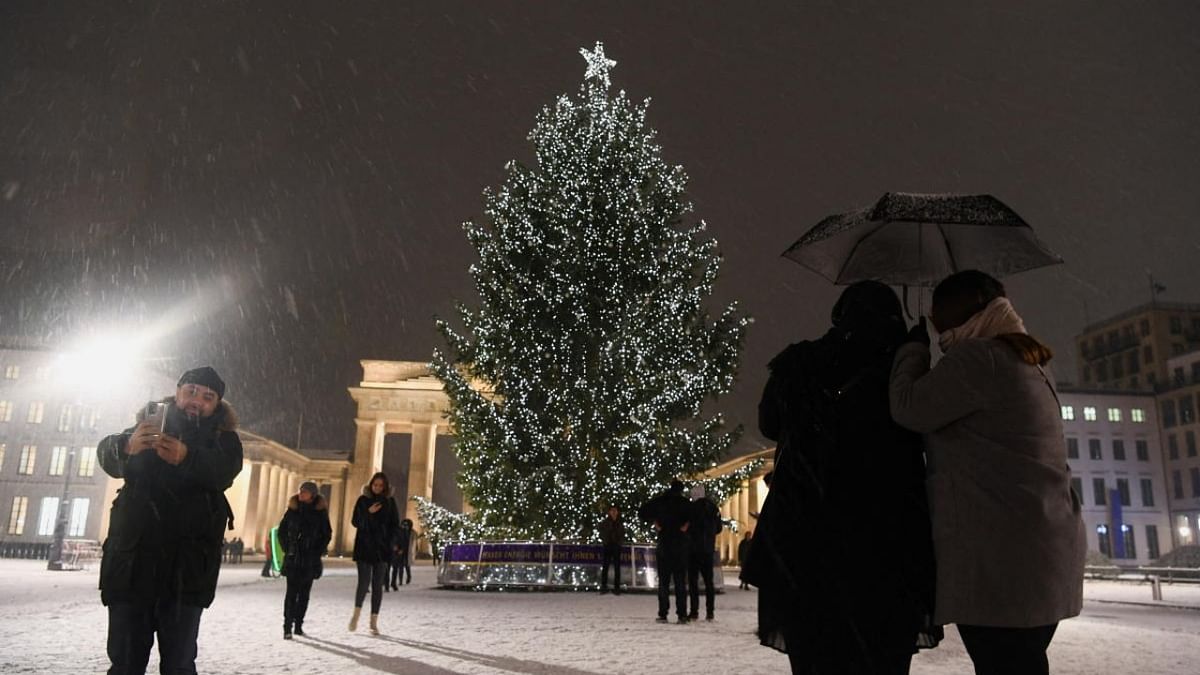 People stand near Brandenburg Gate during snowfall, in Berlin. Credit: Reuters photo