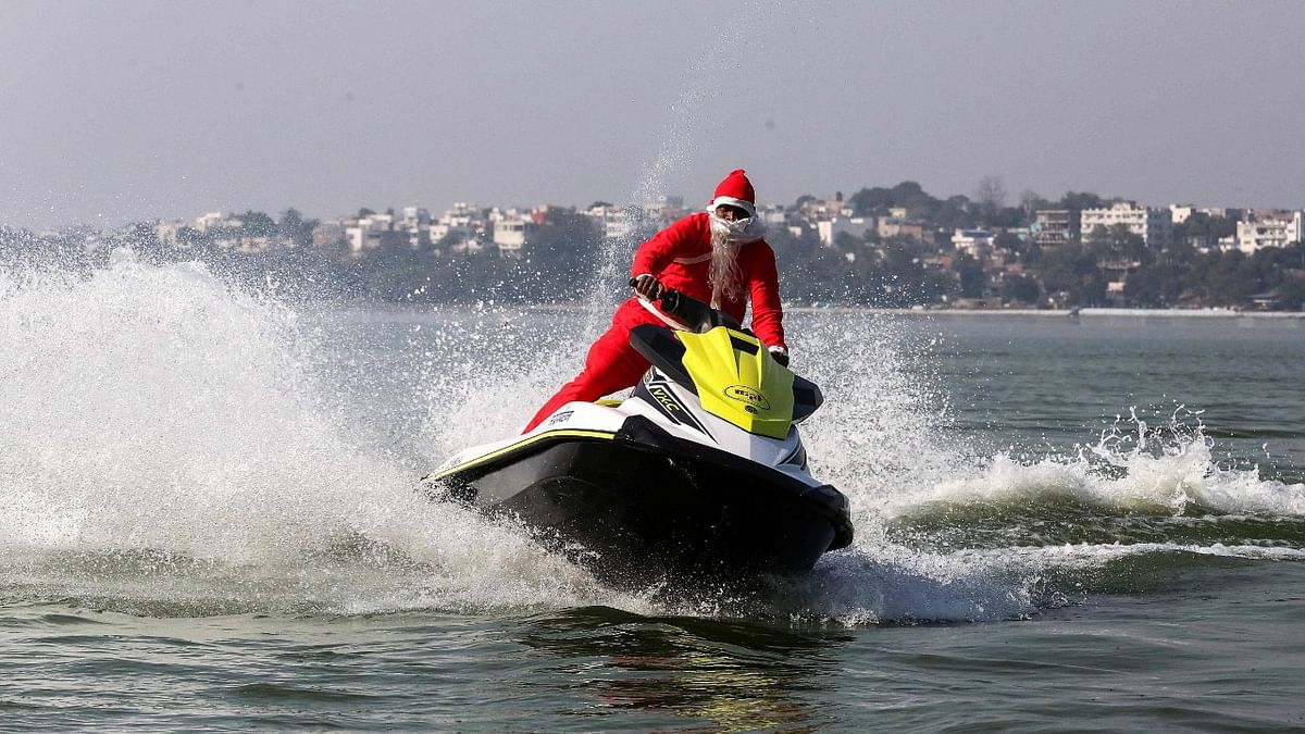 A man dressed as Santa Claus rides a water scooter on the eve of Christmas, at Upper Lake in Bhopal. Credit: PTI Photo