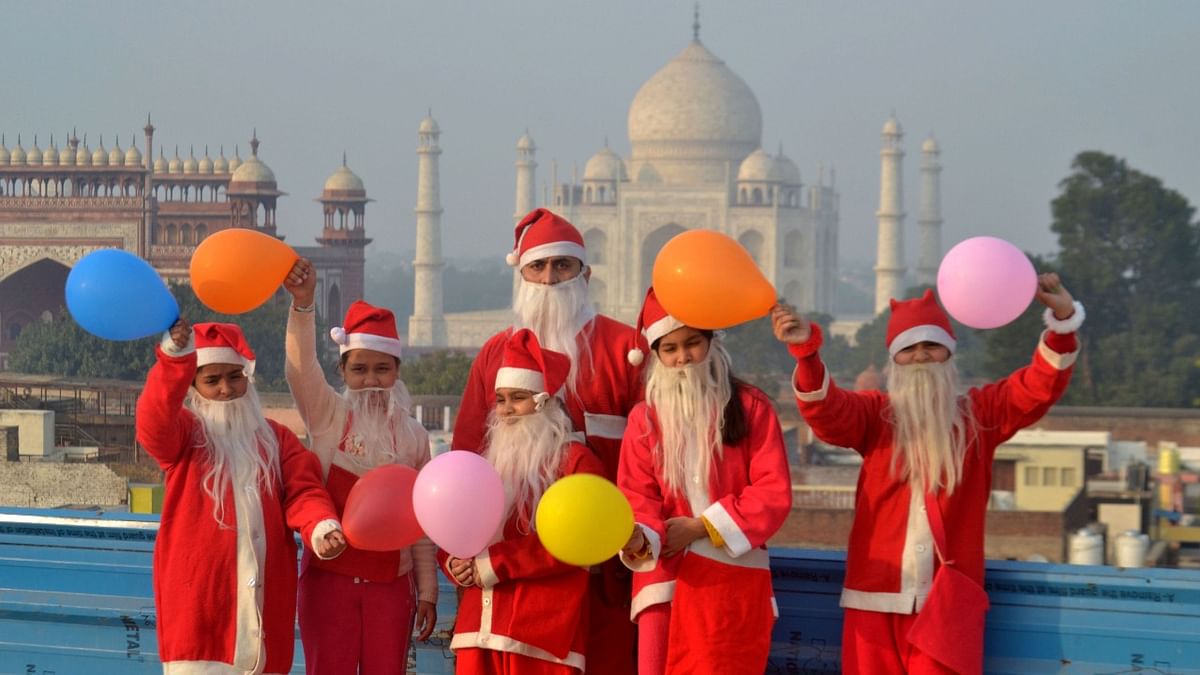 Children and youth drssed in Santa Claus costumes celebrate Christmas, at Taj Mahal in Agra. Credit: PTI Photo