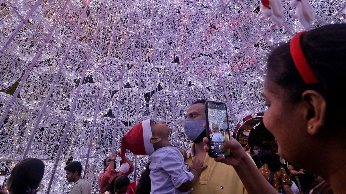 People take pictures inside an illuminated Christmas tree at a mall during Christmas celebrations in Mumbai. Credit: Reuters Photo