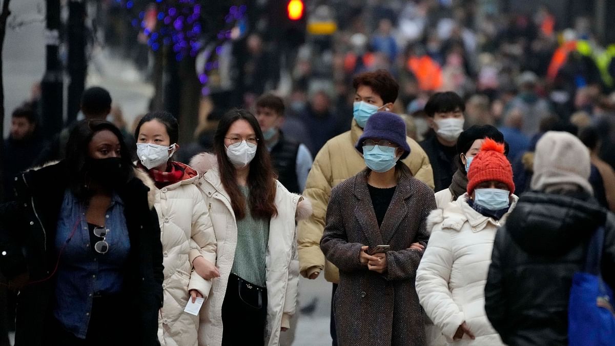 Shoppers wearing face masks walk down Oxford Street, Europe's busiest shopping street, in London. Credit: AP Photo