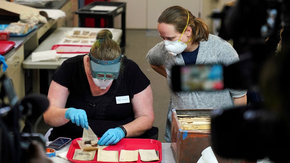 Kate Ridgway, conservator with the Virginia Department of Historic Resources, removes items found in a time capsule recovered from Confederate General Robert E. Lee's monument while Sue Donovan, conservator for Special Collections of the University of Virginia Library, looks on in Richmond, Virginia, US. Credit: Reuters Photo