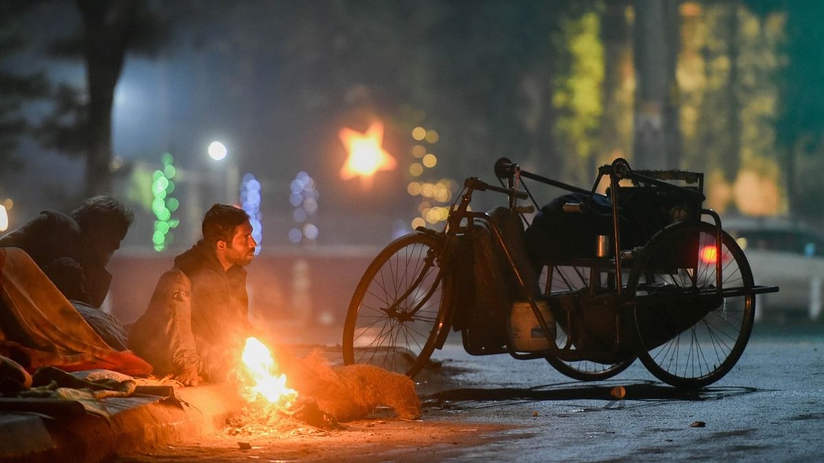 People warm themselves with a bonfire on a cold winter night in New Delhi. Credit: PTI Photo
