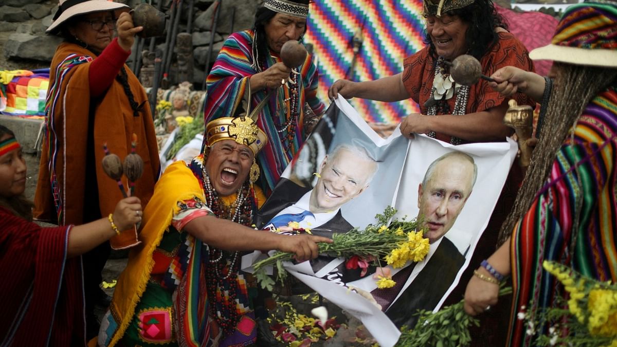 Peruvian's shamans give their predictions for 2022 holding photos of US President Joe Biden and Russian President Vladimir Putin, during a traditional ritual prior to New Year's Eve at San Cristobal hill in Lima, Peru. Credit: Reuters Photo