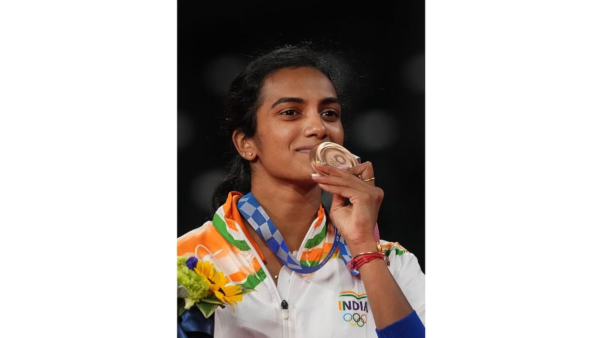 Pusarla V Sindhu poses for photographs while standing on the podium after receiving the bronze medal in women's singles badminton event at the Summer Olympics 2020, in Tokyo. Sindhu became the second Indian athlete after wrestler Sushil Kumar -- and the first woman from the country -- to win two individual Olympic medals. Credit:PTI Photo/Gurinder Osan