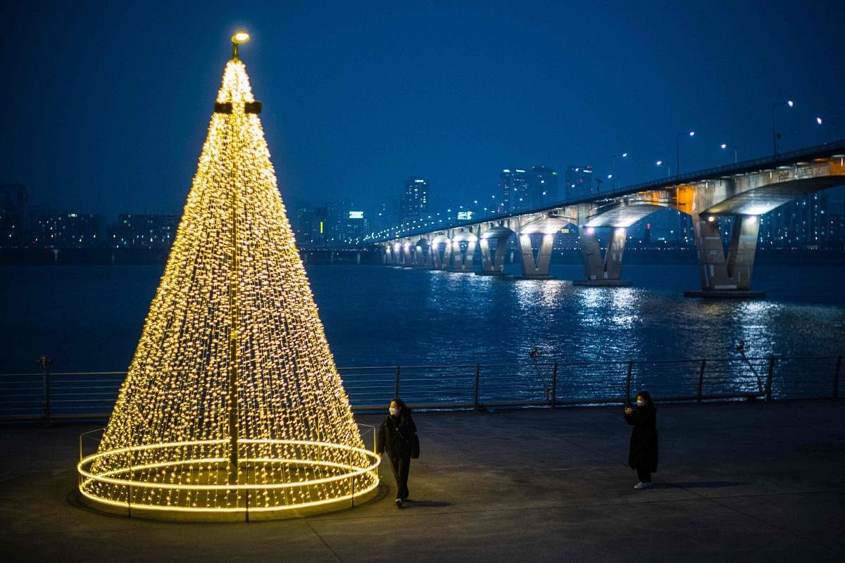 People look at a festive light installation along the Han River in Seoul. Credit: AFP Photo