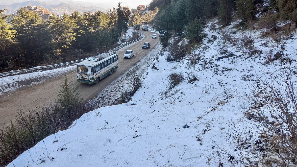 Vehicles move slowly on a slippery road after fresh snowfall at Kufri, near Shimla. Credit: PTI Photo