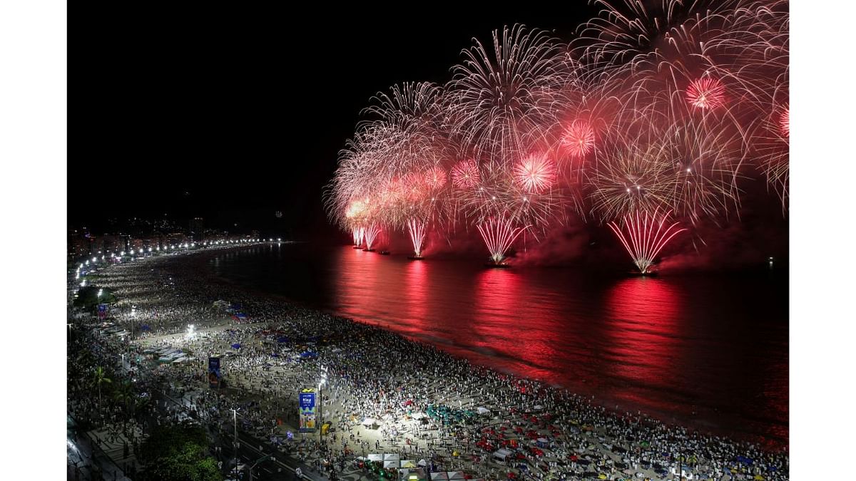 People gather to watch fireworks explode over Copacabana beach during New Year celebrations in Rio de Janeiro, Brazil. Credit: Reuters Photo