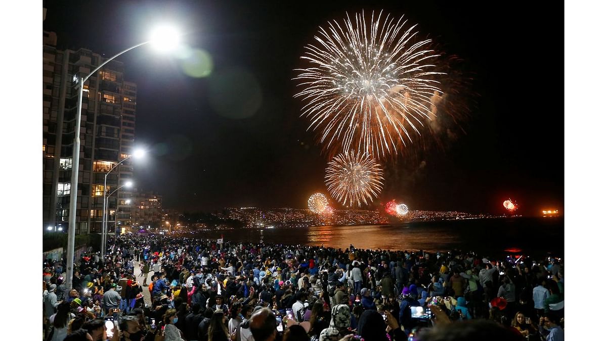 People gather to watch fireworks explode over a beach during New Year celebrations in the coastal city of Vina del Mar, Chile. Credit: Reuters Photo
