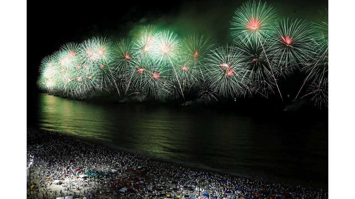 People watch as fireworks explode over Copacabana beach during New Year celebrations in Rio de Janeiro, Brazil. Credit: Reuters Photo