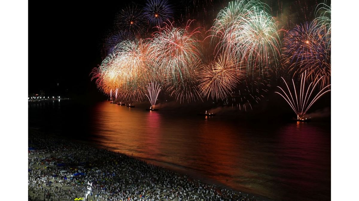 People watch as fireworks explode over Copacabana beach during New Year celebrations in Rio de Janeiro, Brazil. Credit: Reuters Photo