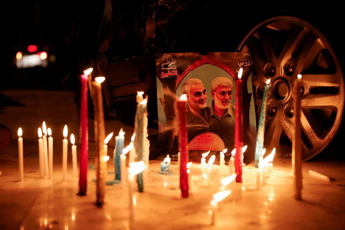 Lit candles are placed next to a picture of Iranian military commander General Qassem Soleimani and Iraqi militia leader Abu Mahdi al-Muhandis during the second anniversary of their killing in a U.S. attack, at Baghdad Airport in Baghdad, Iraq. Credit: Reuters Photo