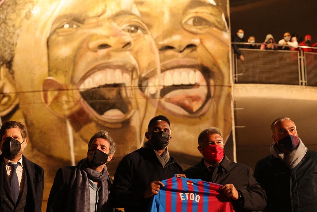 Former RCD Mallorca and FC Barcelona player Samuel Eto'o with FC Barcelona president Joan Laporta hold up a jersey as a mural of Samuel Eto'o is presented outside the stadium before the match. Credit: Reuters Photo
