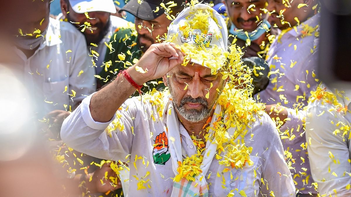 Supporters shower flower petals on KPCC president D K Shivakumar as he walks with party workers, during the 2nd day of the 10-day 'padayatra' from Mekedatu to Bengaluru to demand the implementation of Mekedatu project, in Dodda Alahalli near Bengaluru. Credit: PTI Photo