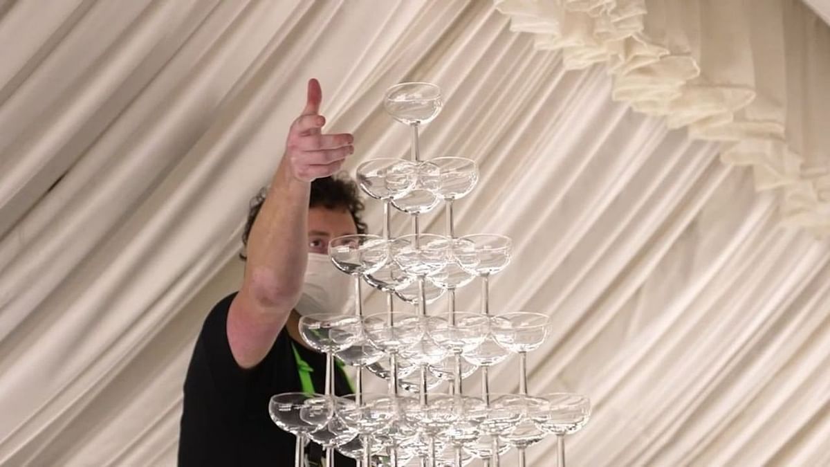 A worker is seen erecting the champagne tower at a hotel in Dubai. Credit: Instagram/maximecasa
