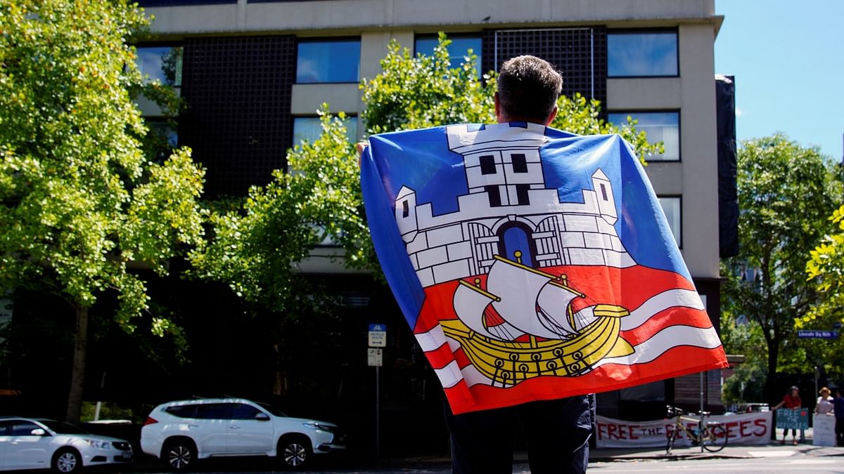 Novak Djokovic's fan flies a Serbian flag in front of the Park Hotel, believed to be holding the Serbian tennis player in Melbourne, Australia. Credit: Reuters Photo