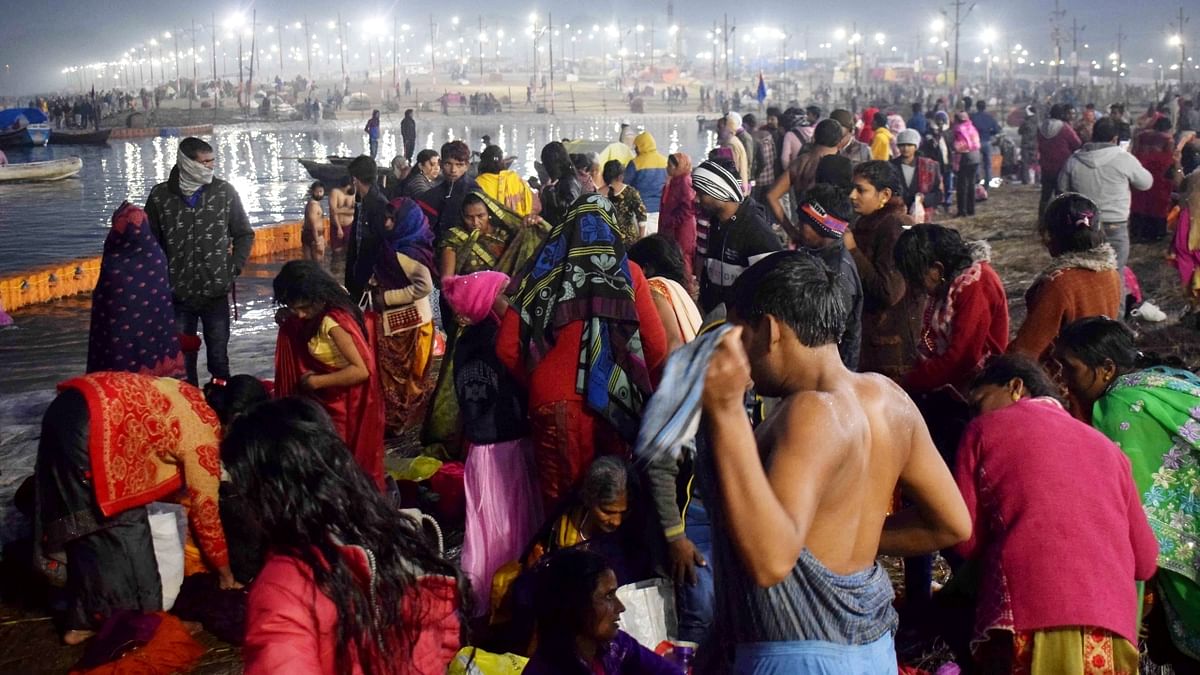 Devotees gather on the banks of Ganga river to take a 'holy dip' on the occasion of 'Makar Sankranti' during the ongoing 'Magh Mela' festival at Sangam in Prayagraj. Credit: PTI Photo