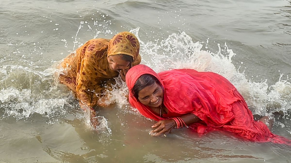 Two elderly women are seen taking the holy dip at Gangasagar in Bengal. Credit: PTI Photo