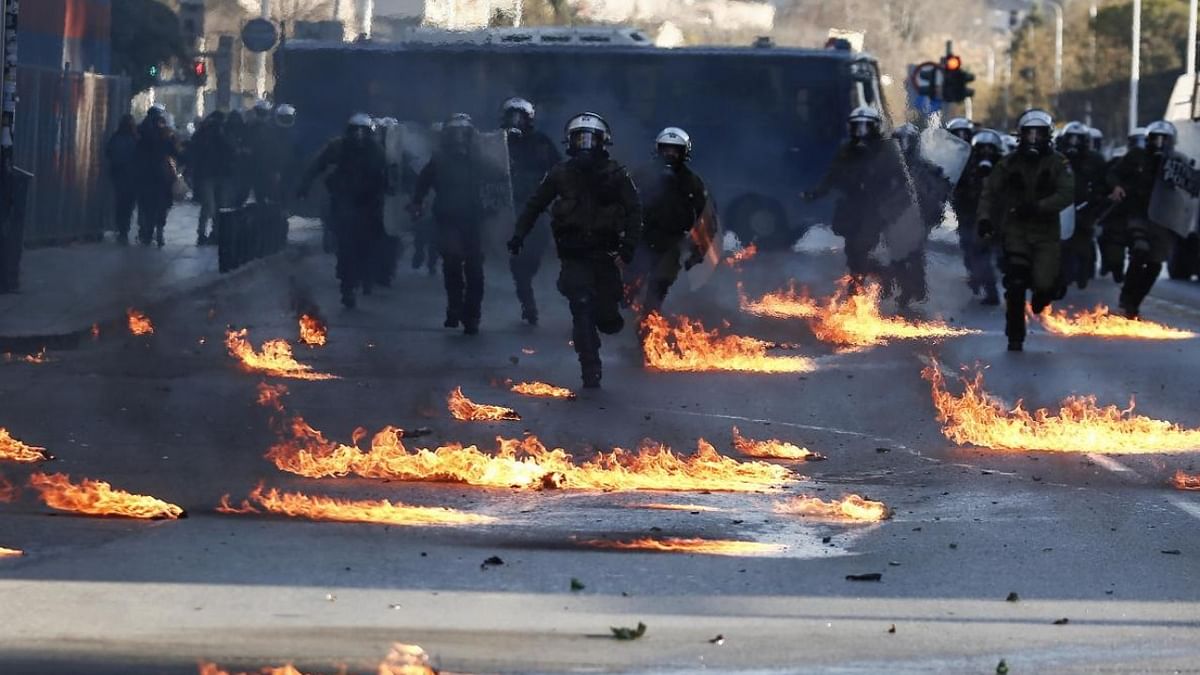 Riot policemen run through flames from petrol bombs during a rally in the northern Greek city of Thessaloniki, Greece. The rally was the culmination of a week of protests over the New Year's Eve eviction of activists who had occupied a room at the university's Biology department for 34 years and turned violent towards its end, when some of the marchers threw firebombs and rocks at riot police, who responded with stun grenades and tear gas. Credit: AP/PTI Photo