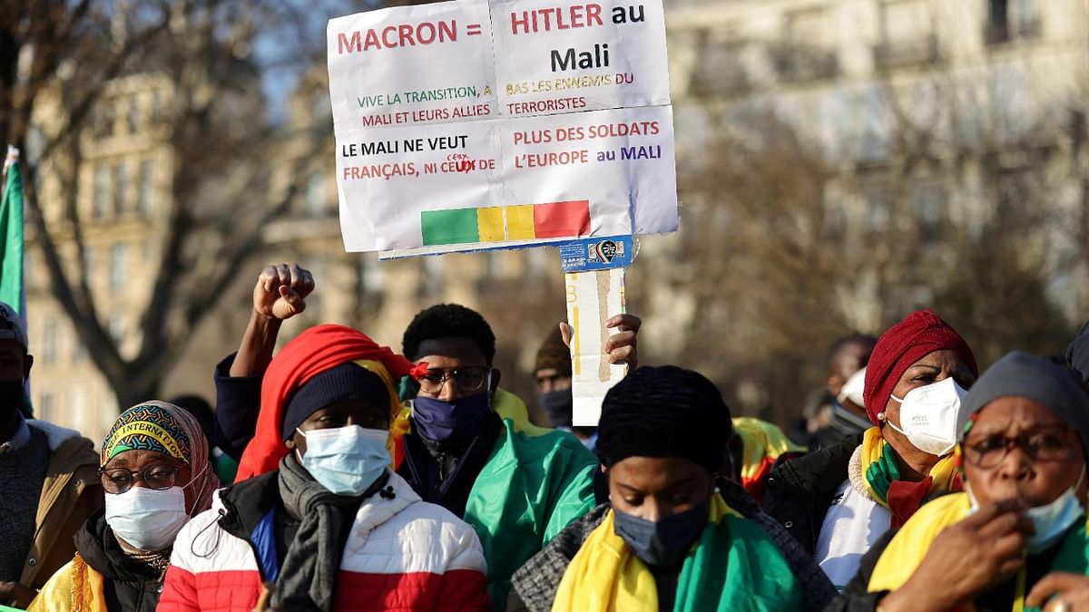 Malian supporter in favor of the ruling military junta, holds a banner reading 'Macron is Mali's Hitler' during a demonstration against France, President Emmanuel Macron's policies, and against the Economic Community of West African States (CEDEAO), near the Ghana Embassy in Paris. Credit: AFP Photo